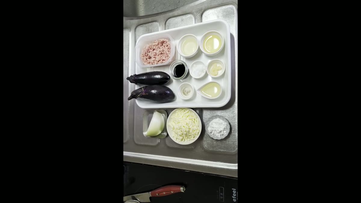 なす、ひき肉、玉ねぎ、調味料など、使用する材料の全体像が分かる。