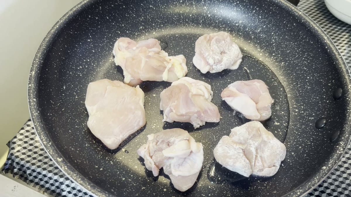 鶏肉をフライパンに並べて焼き始める工程が明瞭です。