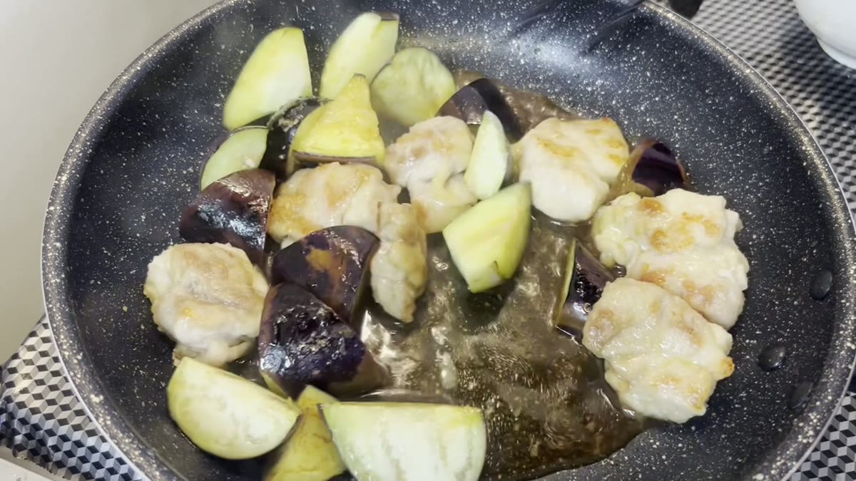 鶏肉となすに調味液を加え、煮絡める後半工程が伝わります。